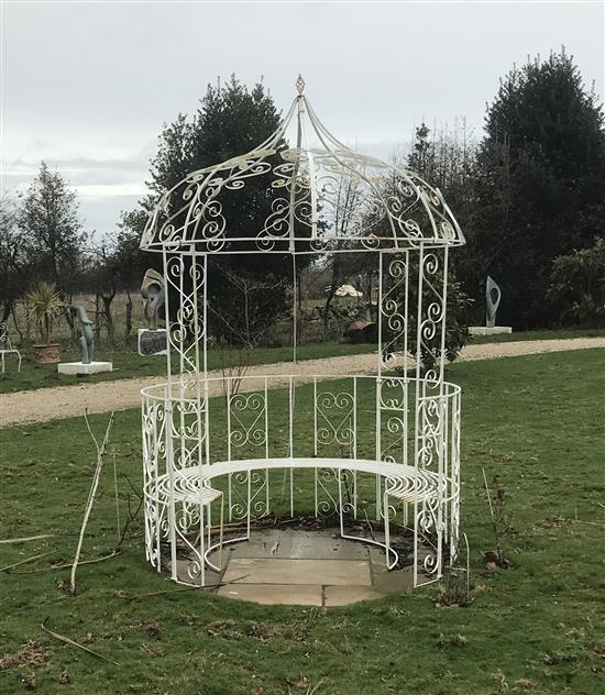 A white painted wrought iron circular gazebo combined seat